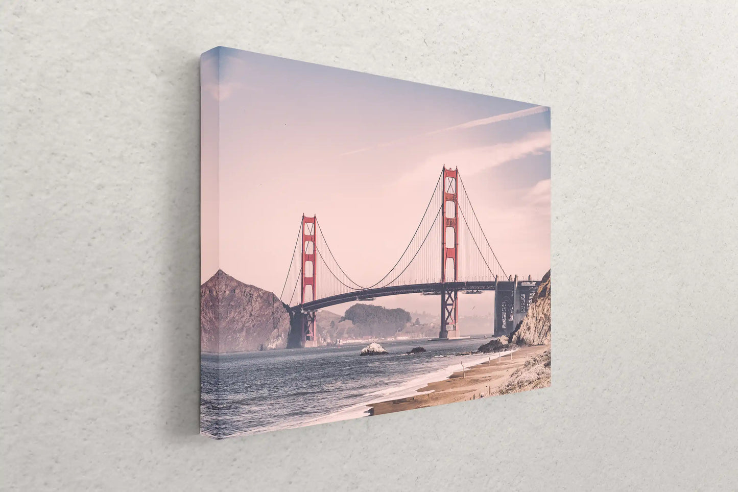 A side view of a canvas print leaning against a wall, featuring a vintage-style photograph of the Golden Gate Bridge with warm tones.