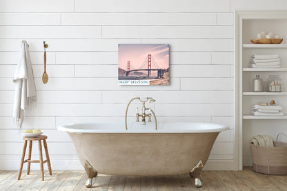 A 16x20-inch print of the Golden Gate Bridge in a vintage style, hung above a bathtub in a white bathroom, serving as a tranquil focal point.