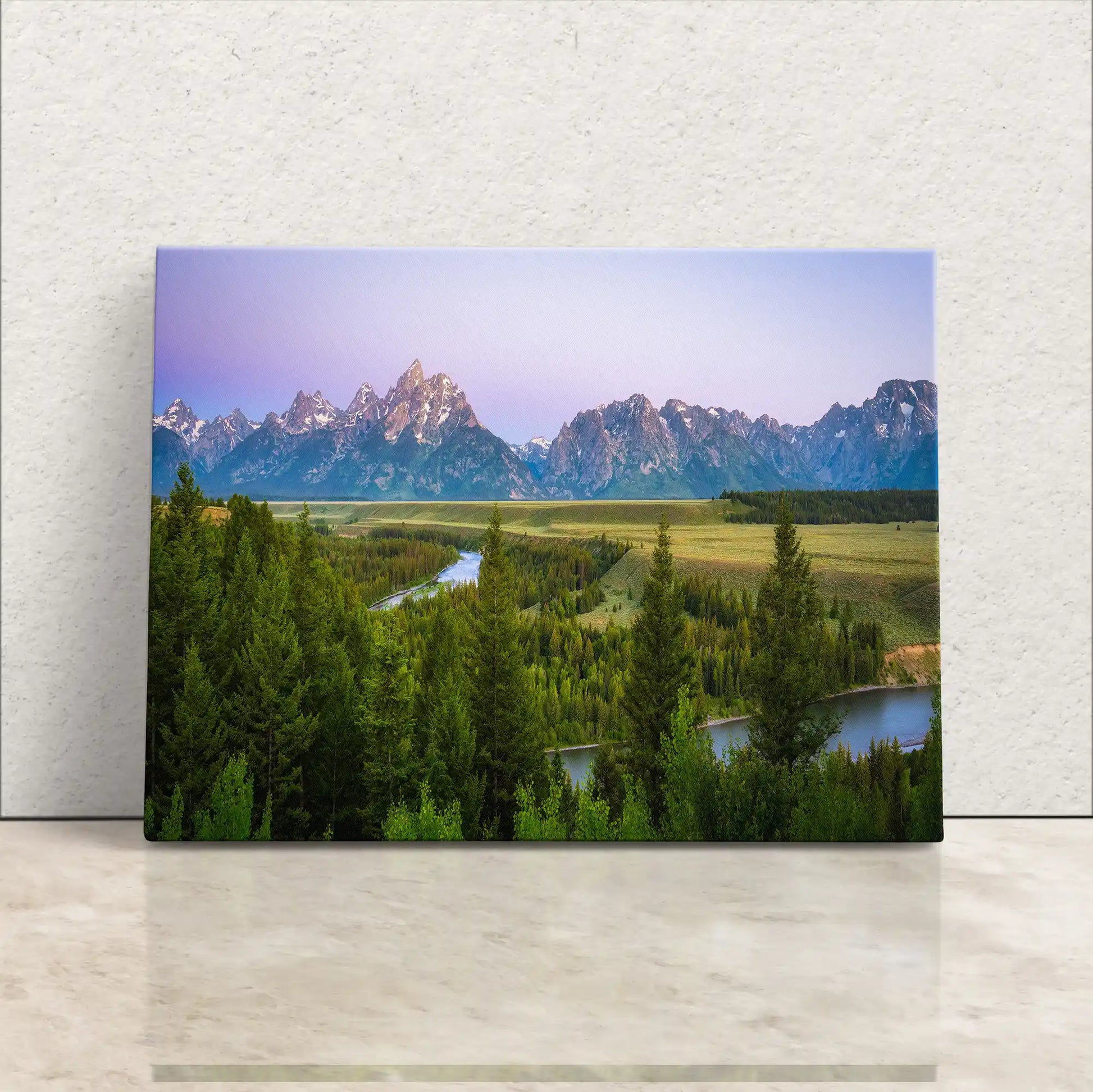 Gallery-wrapped canvas print of Grand Teton Mountains at sunrise with a purple sky and lush greenery in the foreground.