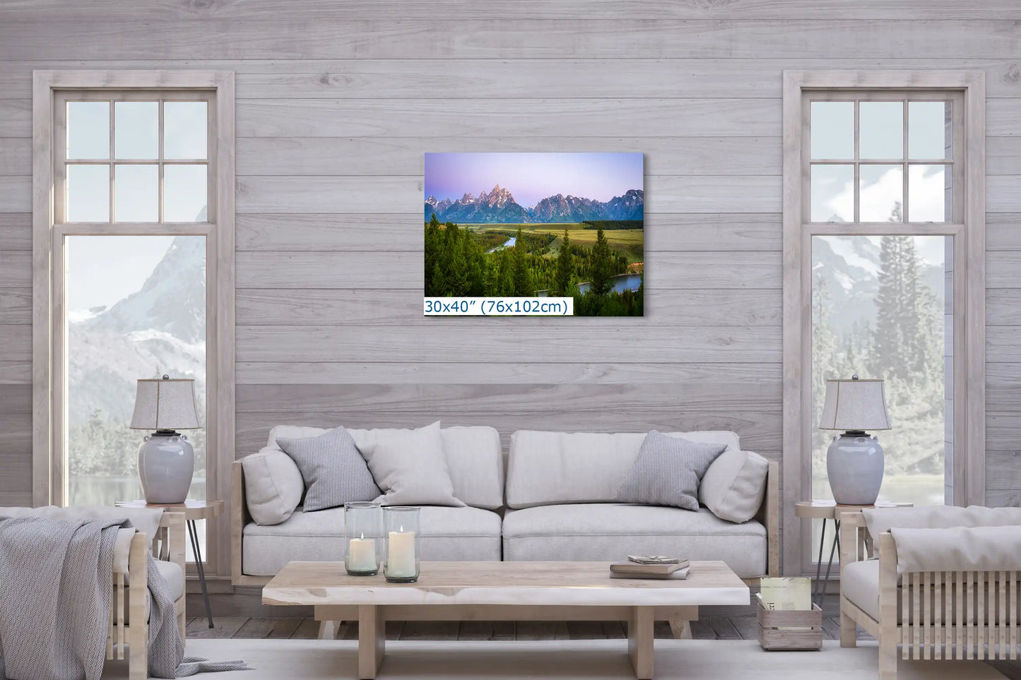 A large 30x40 inch canvas print of Grand Teton Mountains during a purple sunrise in a living room setting above a sofa.