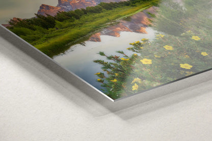 Lush riverside foliage and vibrant yellow wildflowers foreground the majestic Grand Tetons reflected in Snake River, presented on a sleek metal print.