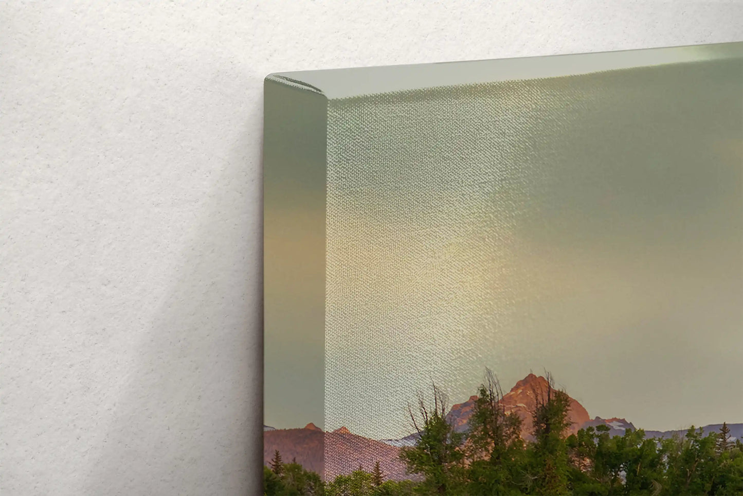 Detailed view of a canvas edge showing the print wrap of the Grand Teton Mountains at sunrise, emphasizing the image continuity.