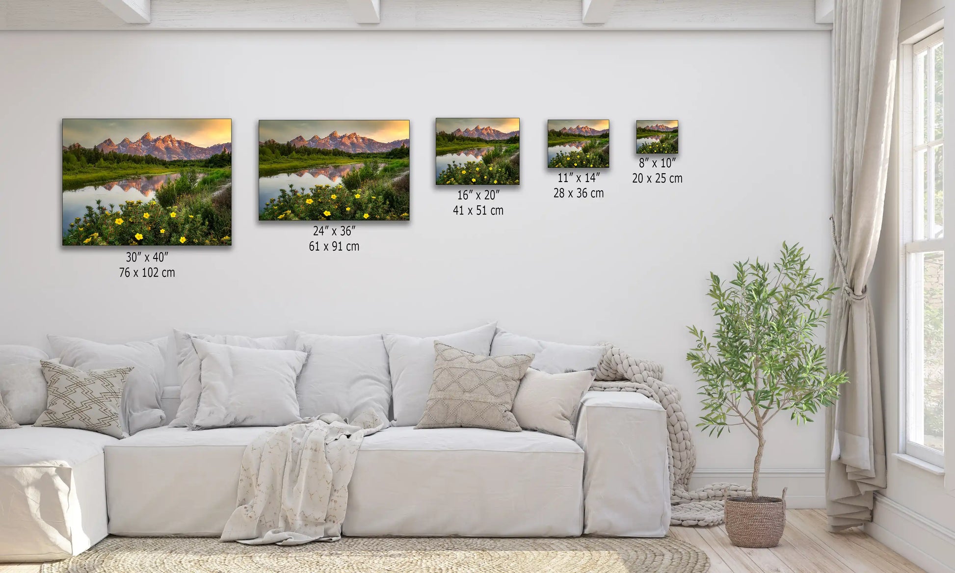 A series of canvas prints in varying sizes displayed over a couch, each depicting the Grand Teton Mountains at sunrise with lush wildflowers.