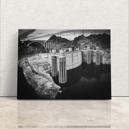 Front view of canvas wall art displaying a black and white photograph of Hoover Dam, with detailed rock textures and reflective water.