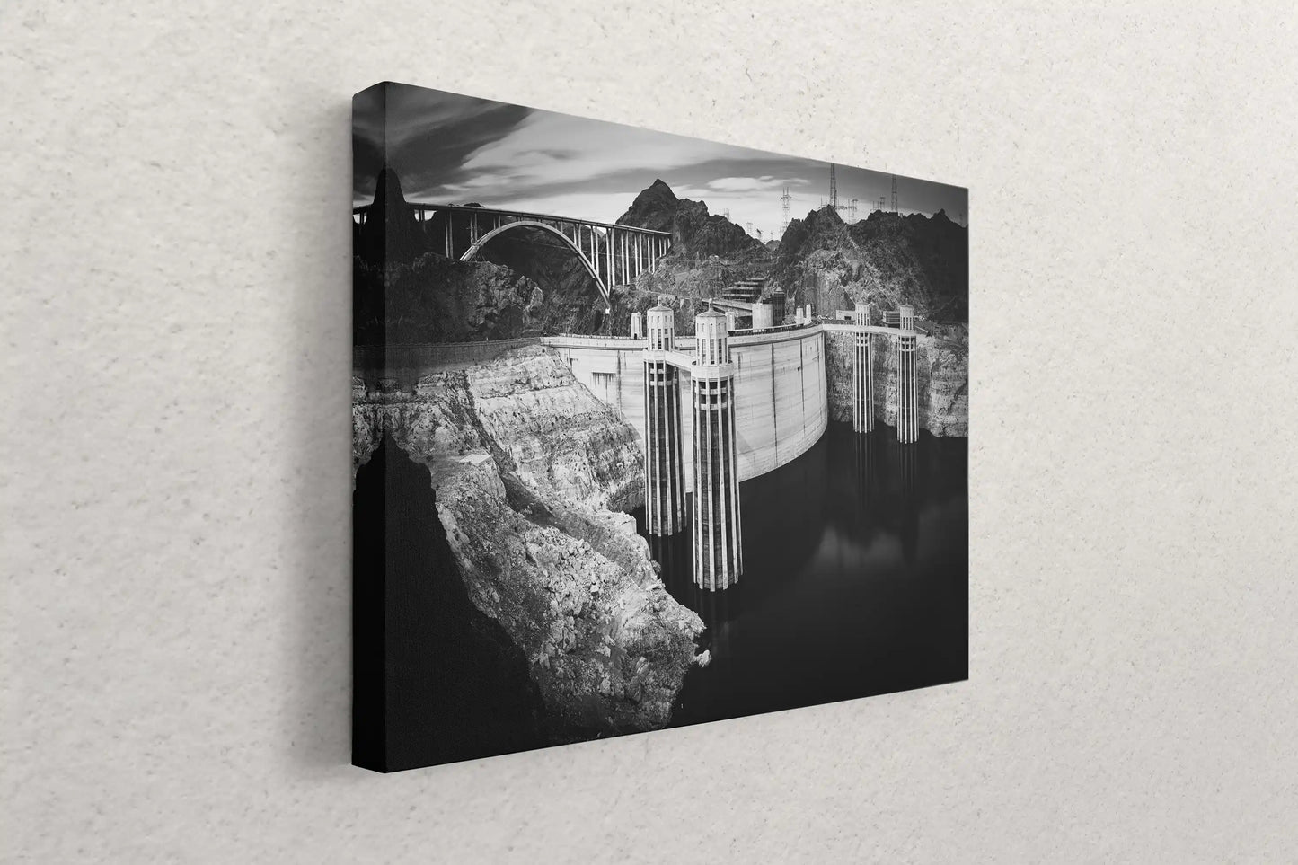 A canvas wall art piece hanging on a wall, featuring a black and white photograph of the Hoover Dam, ready to add a dramatic touch to any room.