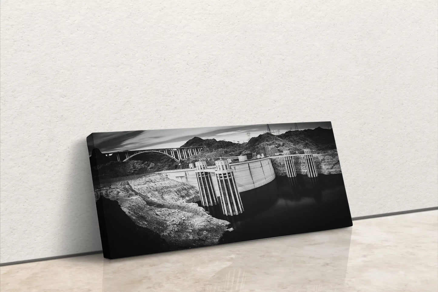 A canvas wall art piece leaning against a wall, featuring a black and white photograph of the Hoover Dam, ready to add a dramatic touch to any room.