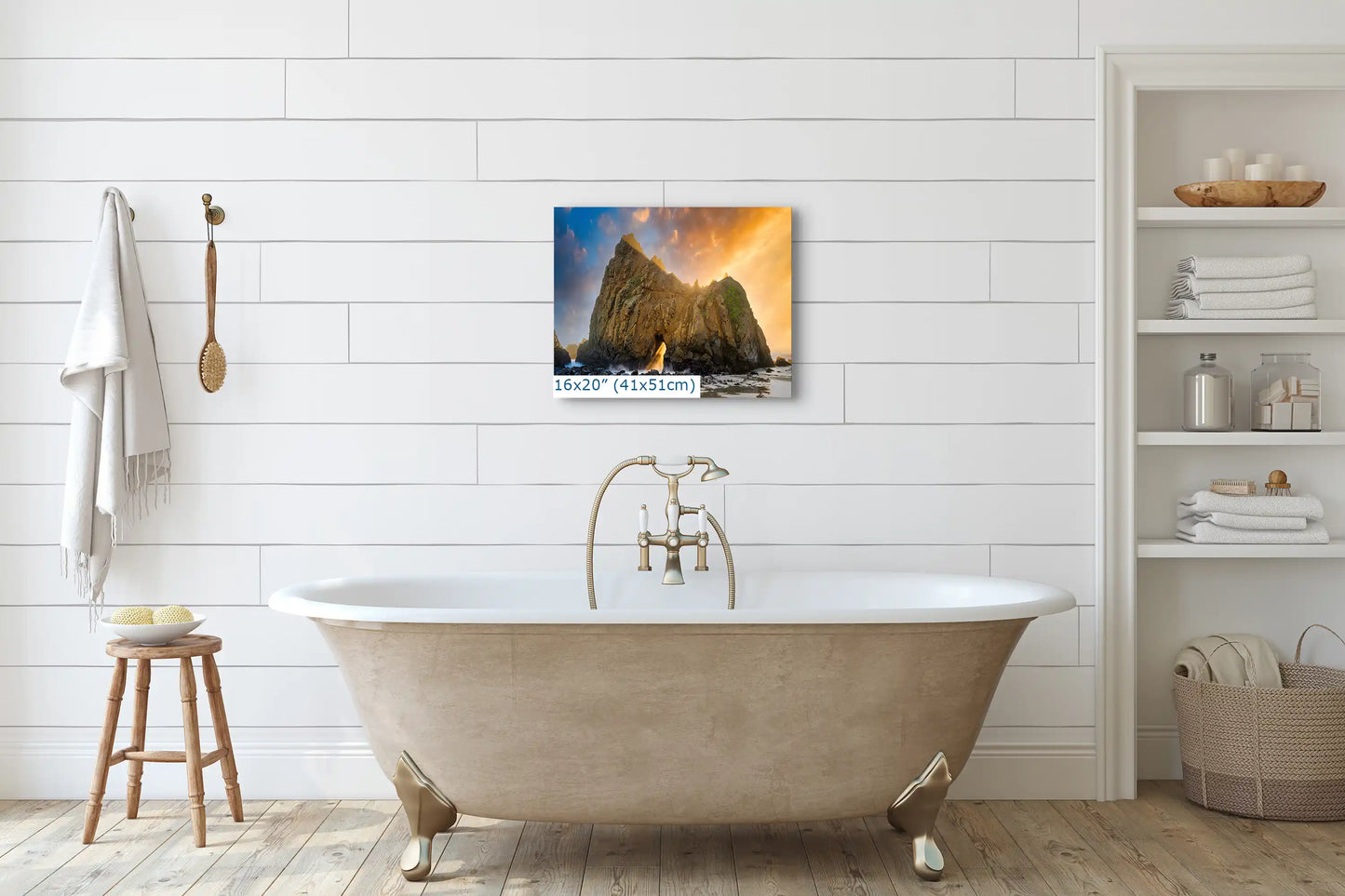 A 16"x20" canvas print above a bathtub, displaying Keyhole Arch in Big Sur with a warm sunset, adding a serene natural element to the bathroom.