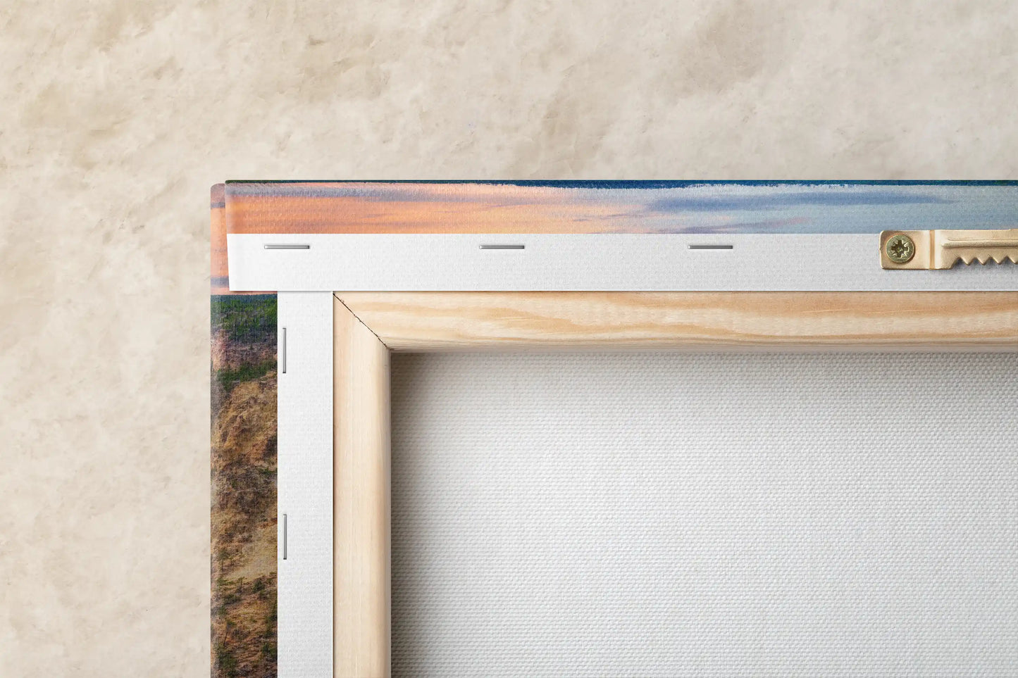 Closeup of a canvas corner showcasing a vivid print of Lower Yellowstone Falls at sunset, highlighting the artwork's texture and color depth.