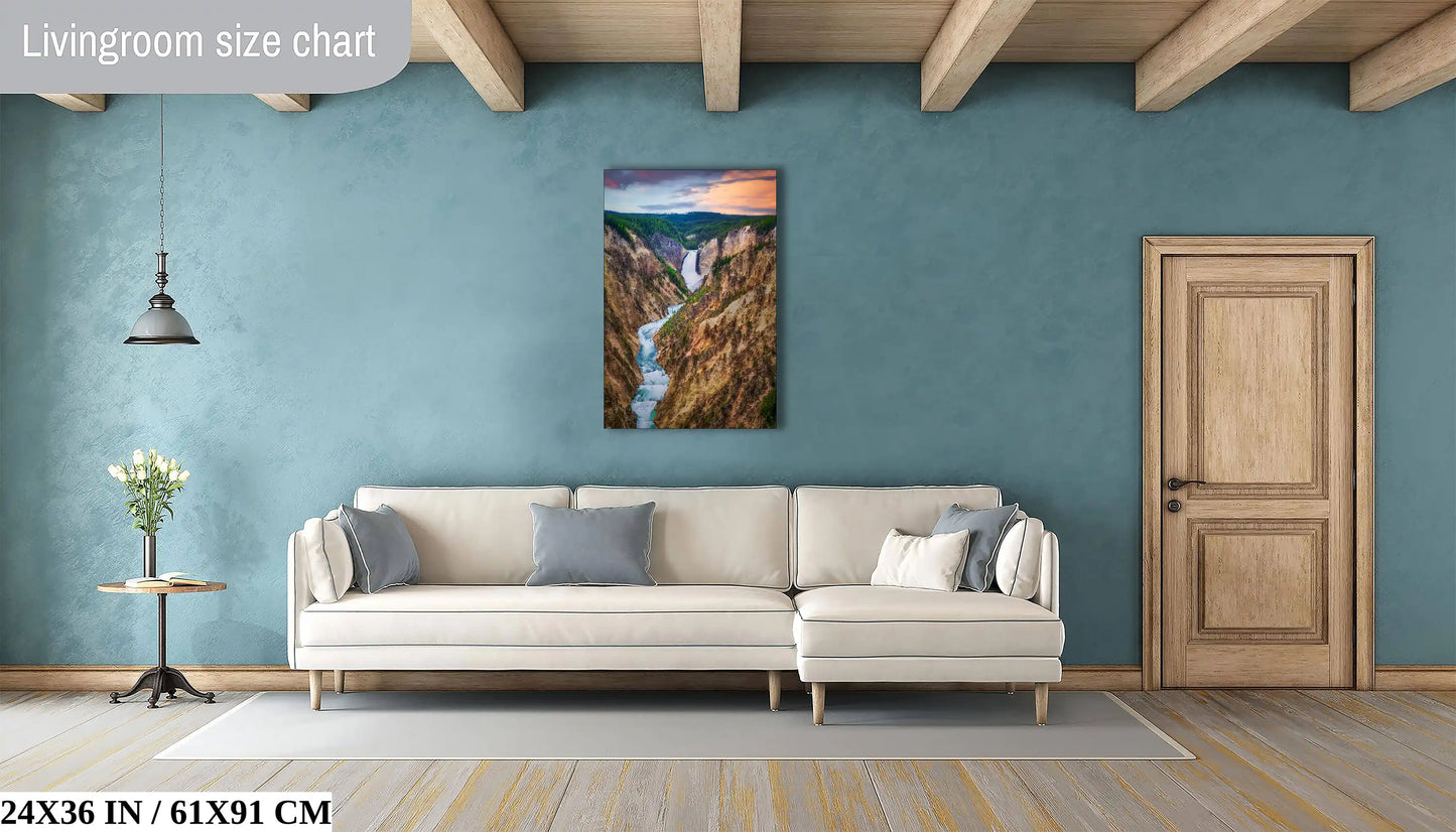 A 24x36 inch canvas print of Lower Yellowstone Falls at sunset in a cozy living room setting above a modern sofa.