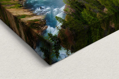 Corner close-up of canvas art depicting the rushing waters of Lower Yellowstone Falls surrounded by steep cliffs and lush greenery, showcasing the raw beauty of Yellowstone.