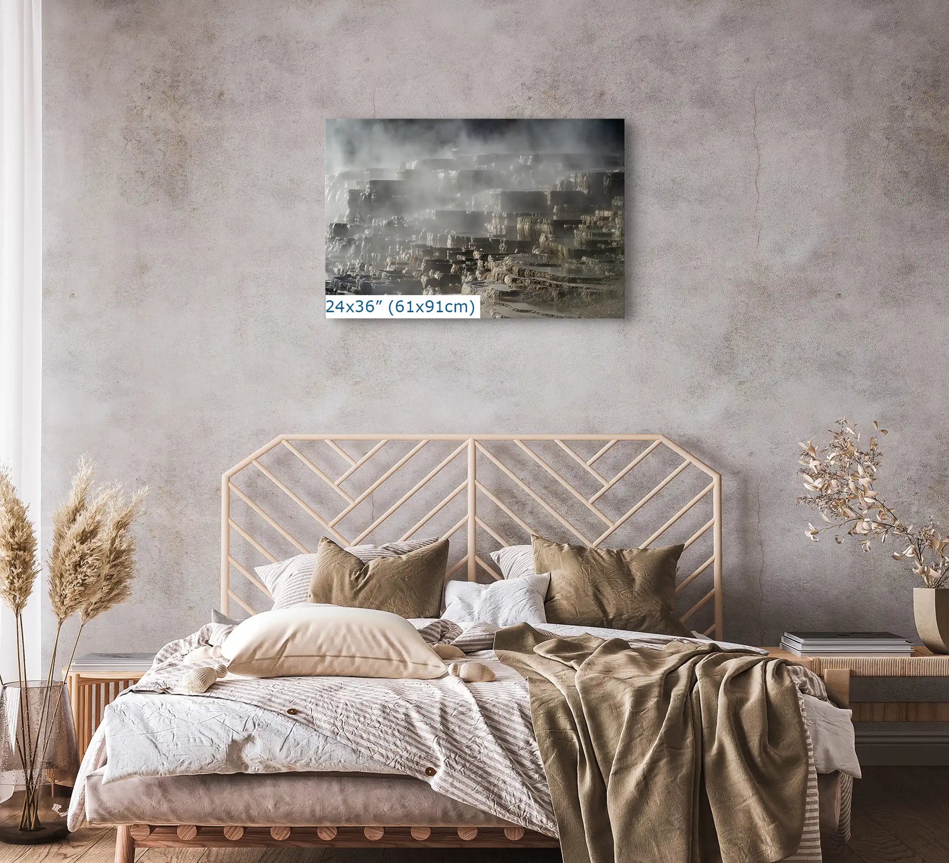 A 24x36 inch canvas print of Mammoth Hot Springs Terraces, centered above a bed with neutral bedding.