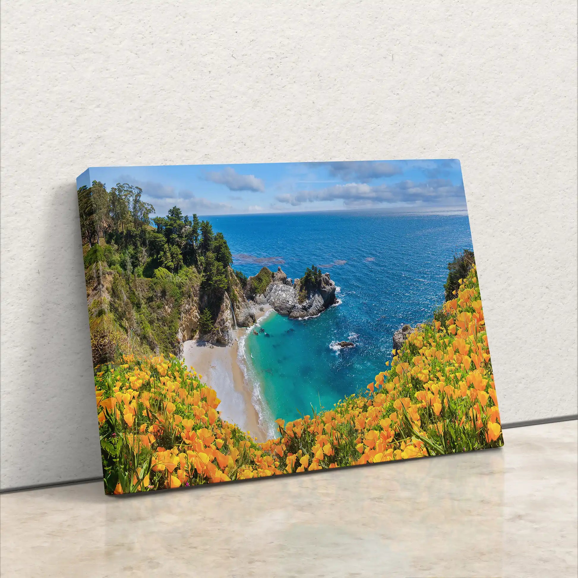 Angled view of a canvas wall art of McWay Falls in Big Sur, emphasizing the contrast between the vibrant flowers and the clear blue sea.