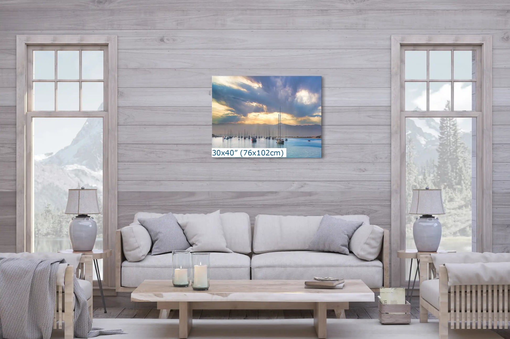 A large 30x40 inch canvas print over a sofa in a living room, depicting a picturesque sunrise over a calm harbor with boats.