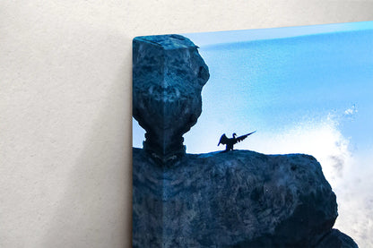 Corner view of a canvas print depicting Morro Rock silhouette and a bird in flight against a blue sky, highlighting the canvas thickness.