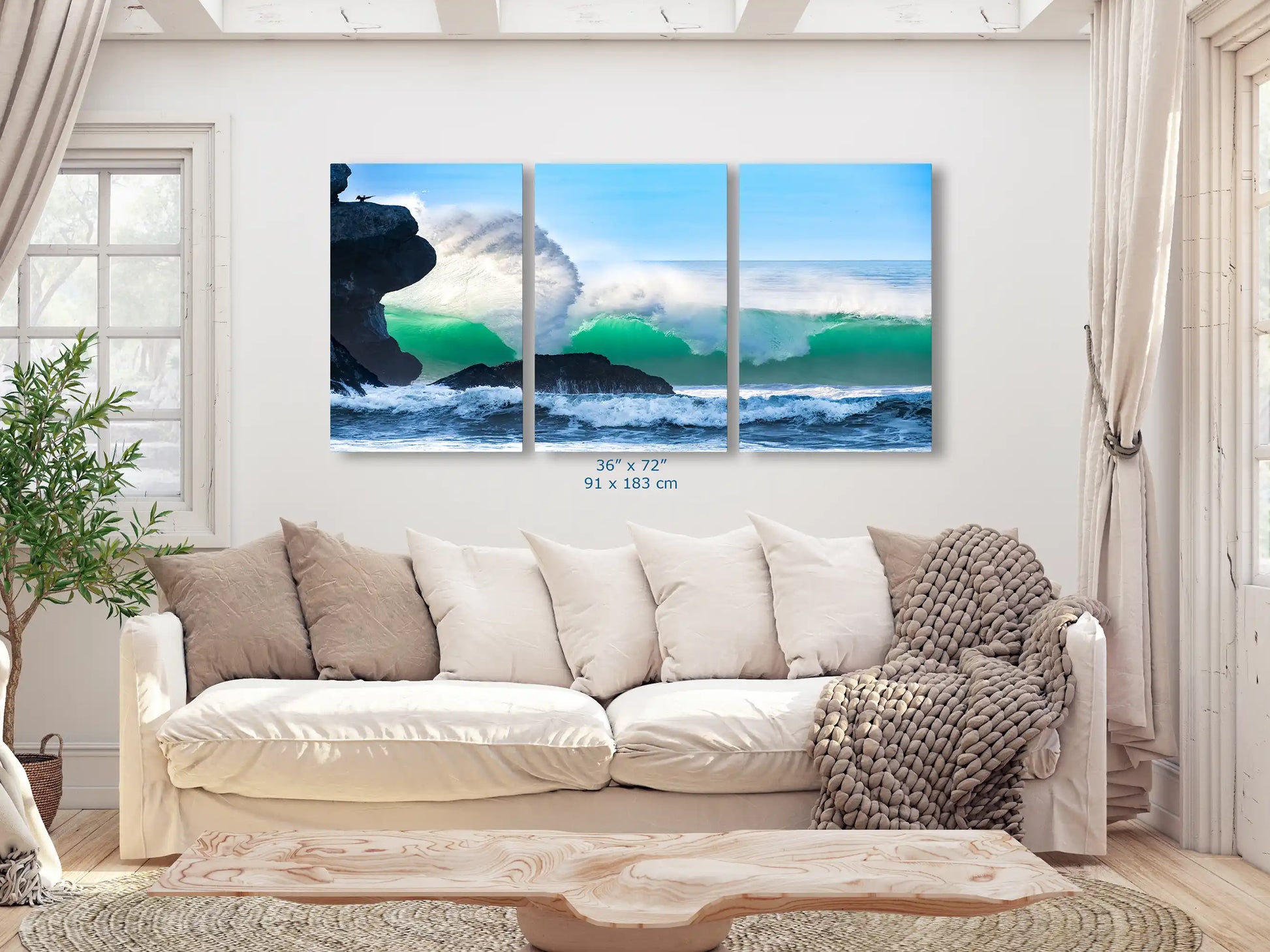 A 36"x72" oversized canvas print of a dramatic ocean wave at Morro Rock, serving as an impressive centerpiece in a living room.
