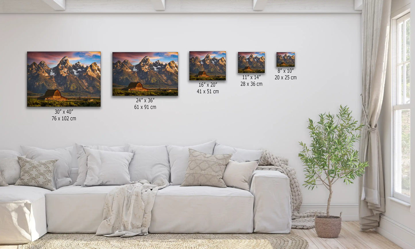 A size comparison chart for wall art featuring the John Moulton Homestead and Teton Mountains at sunrise, displayed over a couch for scale.