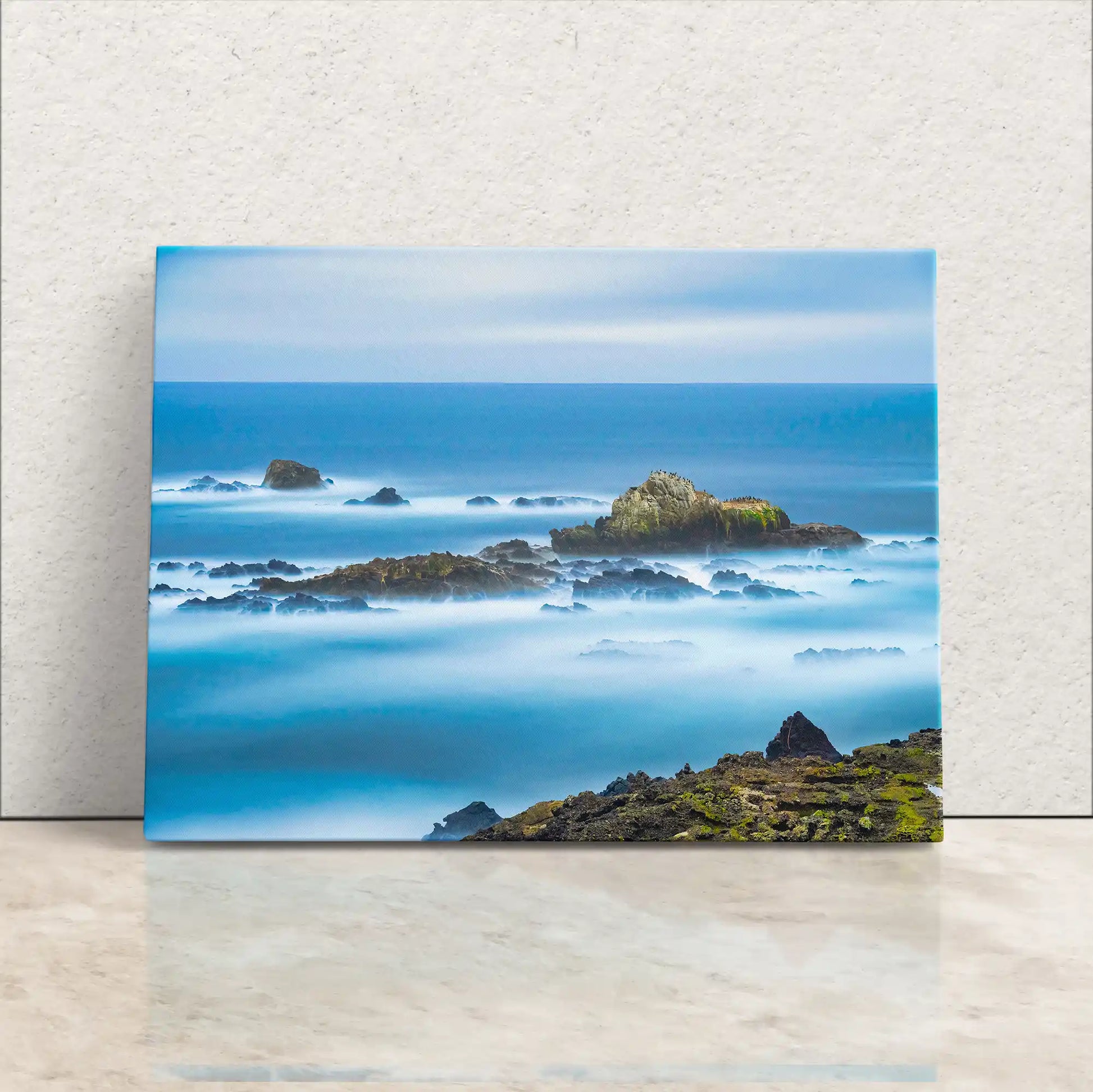 Canvas print of Point Lobos seascape propped against a wall, showcasing misty ocean waves amidst rocky shores.