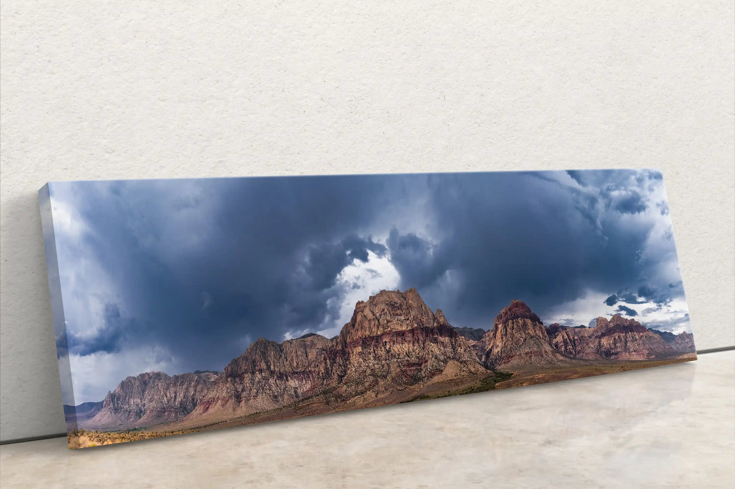 Full front view of a panoramic Red Rock Canyon canvas print, leaning against a white wall, emphasizing the wide and immersive landscape.