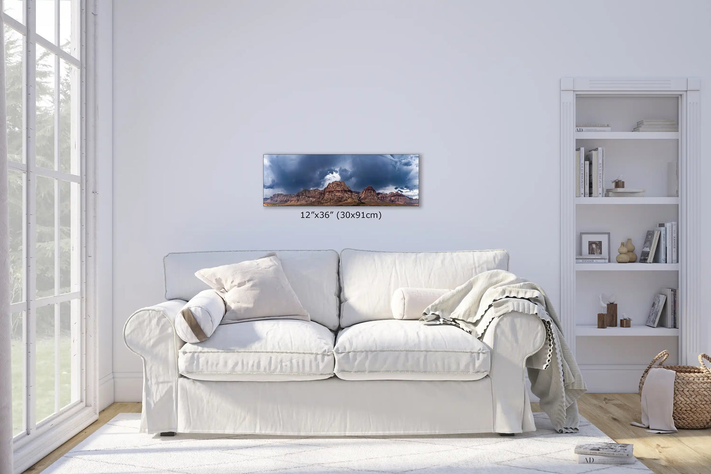 A 12"x36" canvas print of Red Rock Canyon, mounted above a sofa in a sunlit living room, creating a natural and serene focal point.