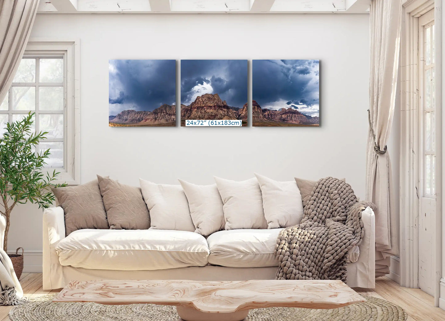 A triptych of Red Rock Canyon canvas prints, each 24"x72", spread across a living room wall above a couch, showcasing the vast landscape.