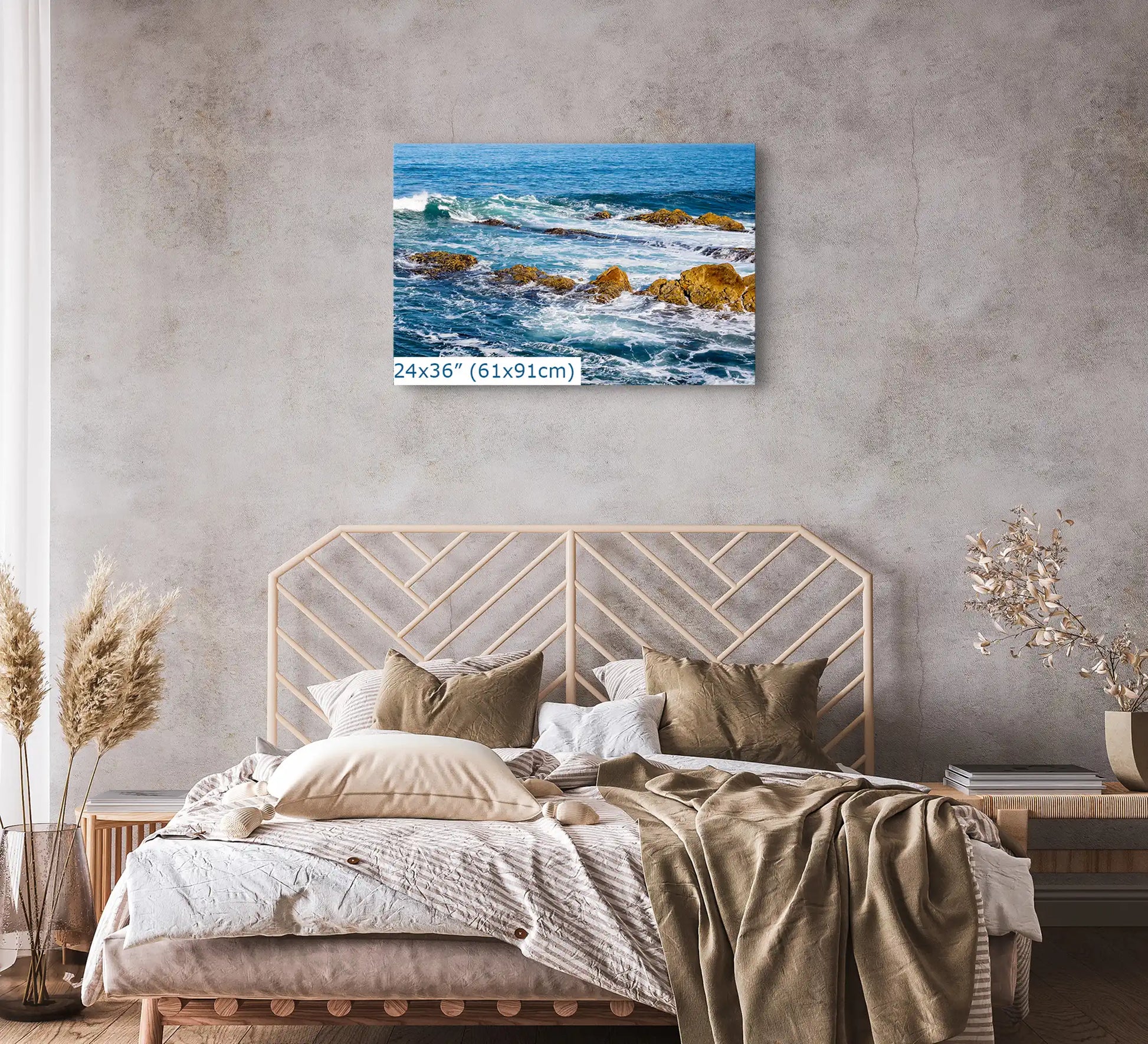 A 24"x36" canvas of the ocean scene prominently displayed above a bed with neutral bedding in a bedroom with a rustic aesthetic.