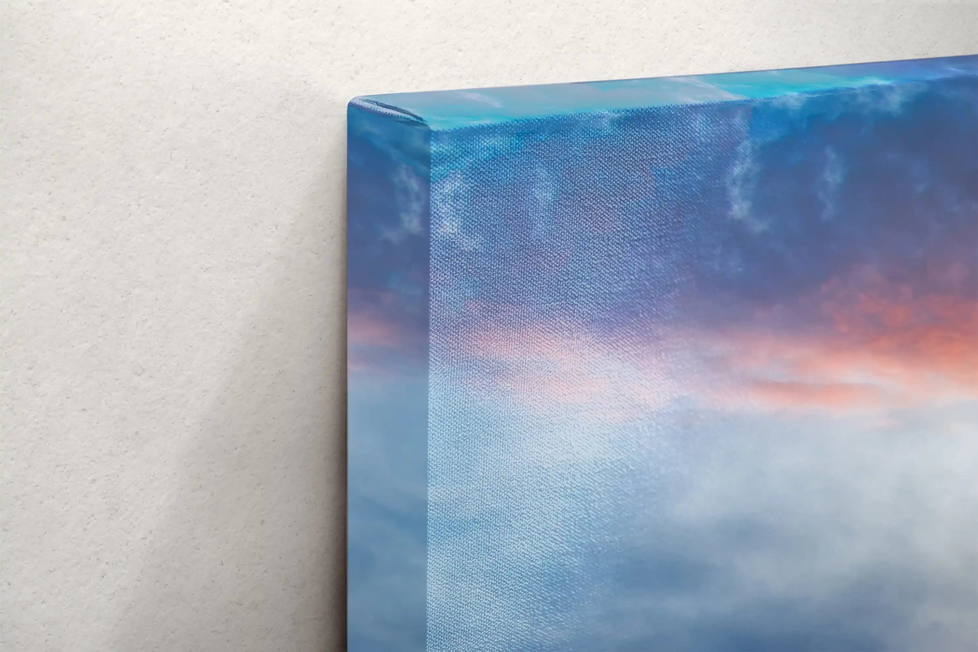 Side view of a canvas wall art displaying the vibrant colors of a stormy sunrise over Yellowstone Lake Forest reflected in water.