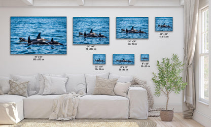 Orca (Killer Whale) family wall art in various sizes displayed above a white sectional sofa in a modern living room.