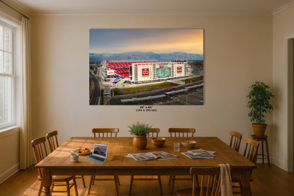 a large framed photograph of a stadium, with a scenic mountain landscape in the background.