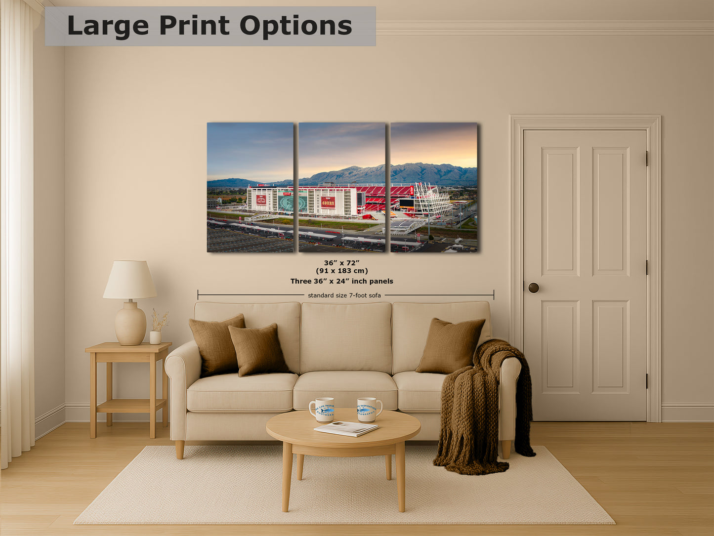 The image is a living room with a large, colorful, and detailed painting of a stadium or sports arena displayed on the wall. The painting is composed of three panels, and the dimensions are provided as 36 inches by 57 inches.