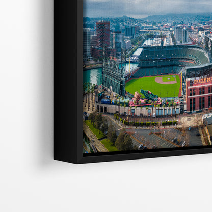 The image is an aerial view of a baseball stadium and surrounding cityscape, with a black frame surrounding the photograph.
